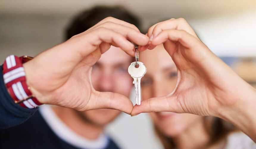 Portrait of a happy young couple proudly displaying the keys to their new house.